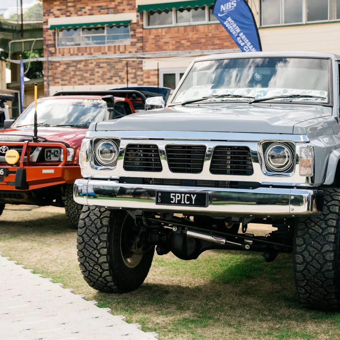 Lifted grey Nissan Patrol with 5PICY plates beside a red Toyota on the club display lawn, National 4x4 Outdoors Show Brisbane